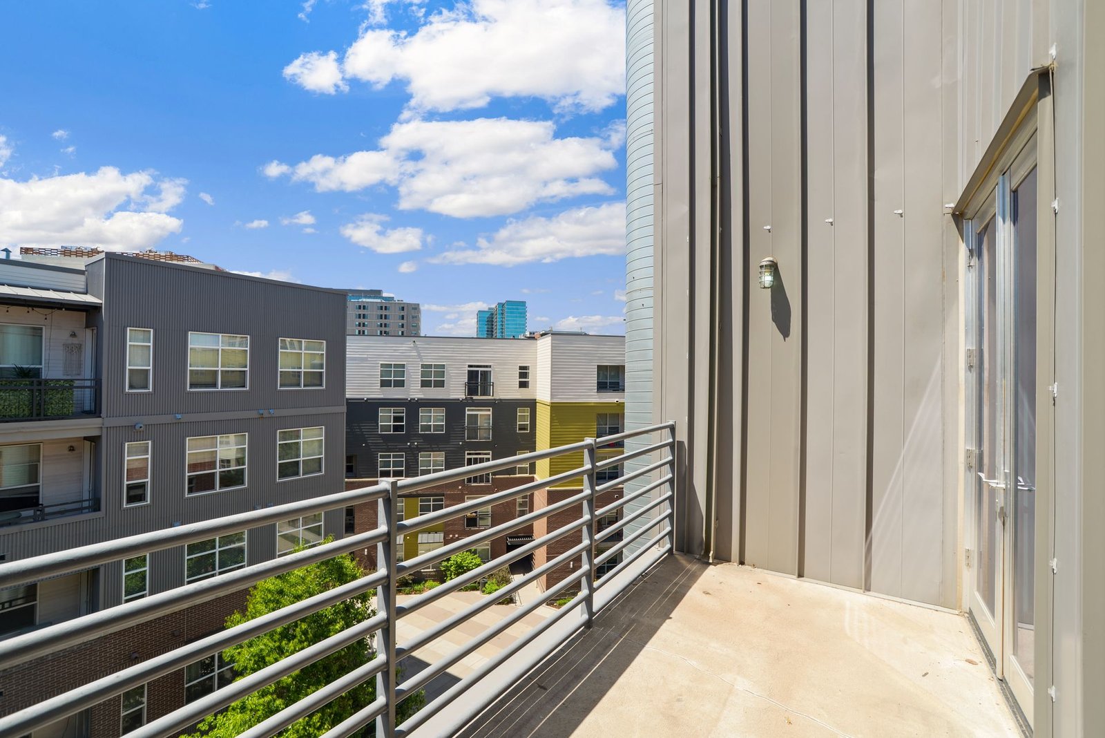 Sunlit modern apartment buildings seen from a balcony