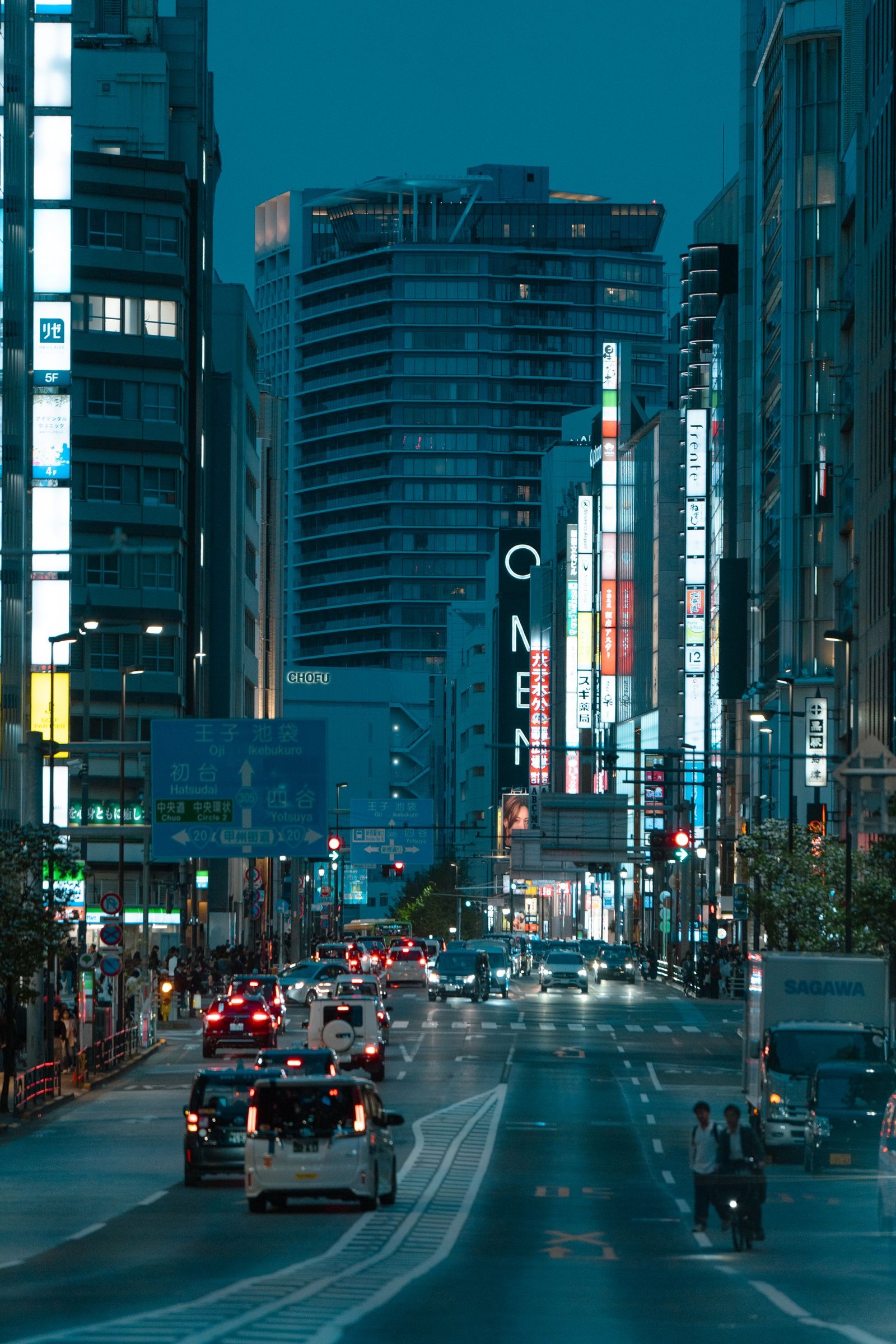 A Tokyo street glowing with neon signs at twilight